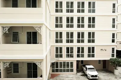 a car parked in a parking lot in front of buildings at One Deves in Bangkok
