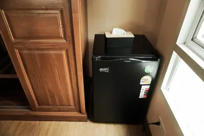 a trash can in a corner next to a door at One Deves in Bangkok