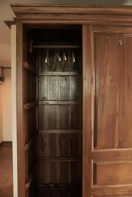 a wooden closet with wooden doors and hangers at One Deves in Bangkok