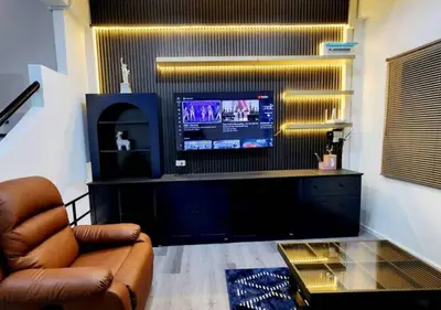 a living room with a couch and a television at Lasalle House - 4- storey entire house with rooftop 200 sqm Suvarnabhumi airport ,BTS in Bangkok