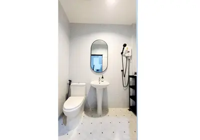 a bathroom with a sink and a toilet and a mirror at Lasalle House - 4- storey entire house with rooftop 200 sqm Suvarnabhumi airport ,BTS in Bangkok