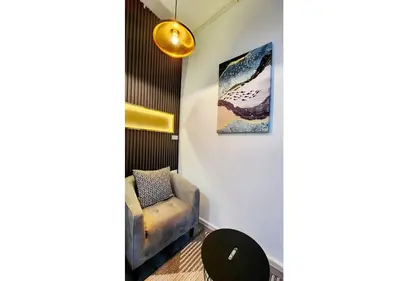 a room with a chair and a painting on the wall at Lasalle House - 4- storey entire house with rooftop 200 sqm Suvarnabhumi airport ,BTS in Bangkok