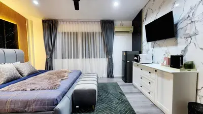 a hotel room with a bed and a tv at Lasalle House - 4- storey entire house with rooftop 200 sqm Suvarnabhumi airport ,BTS in Bangkok