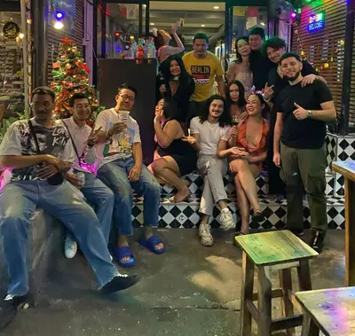 a group of people posing for a picture in a bar at 24 hr Hostel in khaosan road in Bangkok