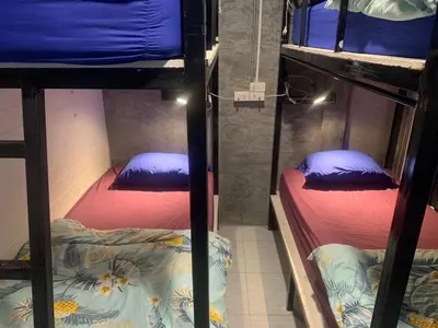 two bunk beds in a room with purple and blue pillows at 24 hr Hostel in khaosan road in Bangkok