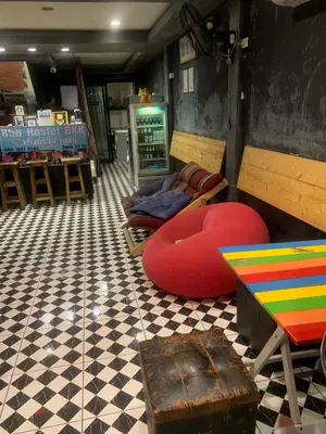 a room with a couch and a table and chairs at 24 hr Hostel in khaosan road in Bangkok