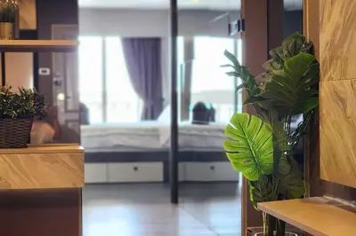 a bedroom with a bed and a potted plant at SelfCheckIn The State Tower RiverView 2Bedroom BTS ICONSIAM Silom Sathon in Bangkok