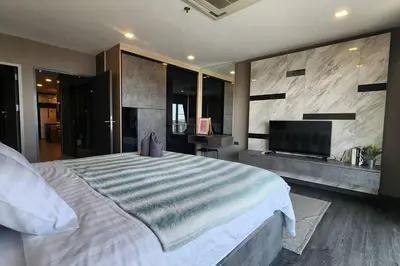 a bedroom with a large bed and a flat screen tv at SelfCheckIn The State Tower RiverView 2Bedroom BTS ICONSIAM Silom Sathon in Bangkok