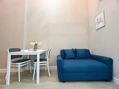 a blue couch sitting next to a table and a table and chair at Metro sky prachachuen in Bang Su