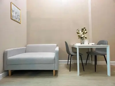 a living room with a chair and a table at Metro sky prachachuen in Bang Su