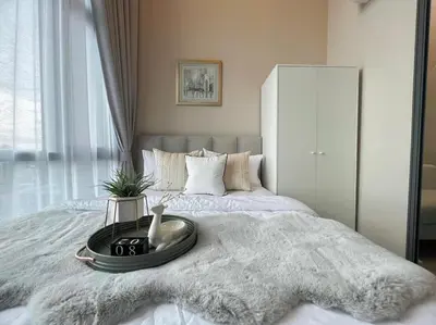 a bed with a tray with a vase on it at Metro sky prachachuen in Bang Su