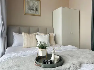 a bed with a tray with a plant on it at Metro sky prachachuen in Bang Su
