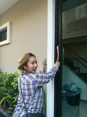 a woman is unlocking a window with a door at Mimi Cozy Apartment- Old town Siriraj Wanglang Market in Bangkok