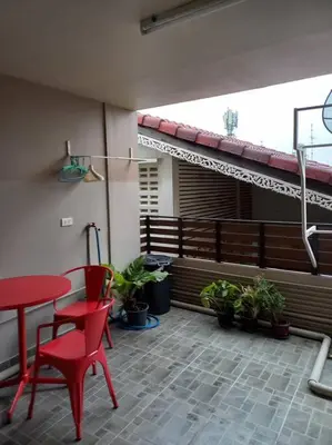 a patio with a red table and chairs and potted plants at Mimi Cozy Apartment- Old town Siriraj Wanglang Market in Bangkok