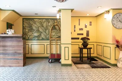a lobby with a waiting area with a clock on the wall at 75 Paradise Lane Managed by Loft Group in Bangkok