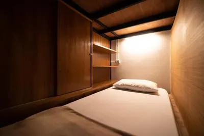 a small room with a bed and a light at Hansa Hostel Bangkok Khaosan in Bangkok