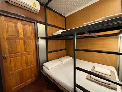 a room with two bunk beds and a door at Hansa Hostel Bangkok Khaosan in Bangkok