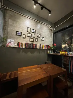 a wooden bench in a room with a table at Hansa Hostel Bangkok Khaosan in Bangkok
