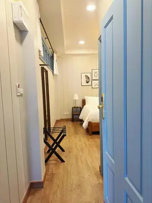 a bedroom with a bed and a blue door at Wiengket Heritage 1964 in Bangkok