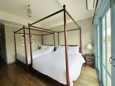 a bedroom with a four poster bed with white sheets at Wiengket Heritage 1964 in Bangkok