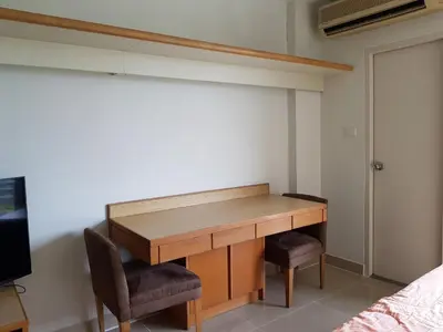 a wooden desk with two chairs in a bedroom at Condo I-House Laguna Garden RCA - Behind Sukhumvit Thonglor Asoke Emporium Bangkok Hospital Piyavet Hospital Makkasan Airport Link MRT SKY TRAIN in Bangkok