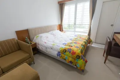 a bedroom with a bed and a chair and a window at Condo I-House Laguna Garden RCA - Behind Sukhumvit Thonglor Asoke Emporium Bangkok Hospital Piyavet Hospital Makkasan Airport Link MRT SKY TRAIN in Bangkok