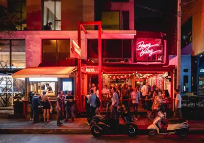 a group of people standing outside a restaurant at night at Holiday Inn Express Bangkok Sukhumvit 11 by IHG in Bangkok