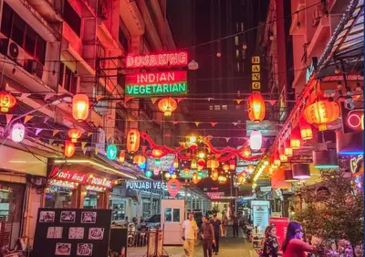 a street at night with lights and people walking around at Holiday Inn Express Bangkok Sukhumvit 11 by IHG in Bangkok