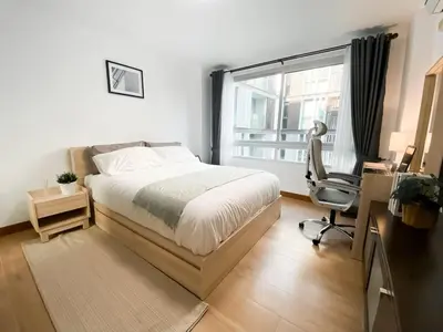 a bedroom with a bed and a desk and a window at Spacious 53 SQM - BTS Thong Lo - Ultra Fast WiFi in Khlong Toei
