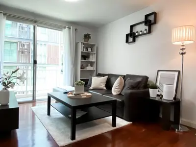 a living room with a couch and a table at Spacious 53 SQM - BTS Thong Lo - Ultra Fast WiFi in Khlong Toei