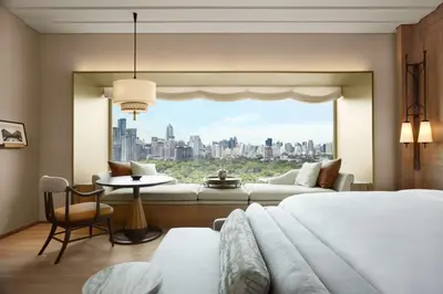 a bedroom with a large window with a view of a city at Dusit Thani Bangkok in Bangkok