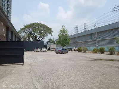a car parked in a parking lot next to a building at My Cocoon Hostel แจ้งวัฒนะ in Nonthaburi