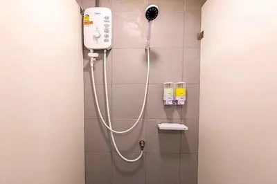 a shower in a bathroom with a blow dryer at My Cocoon Hostel แจ้งวัฒนะ in Nonthaburi