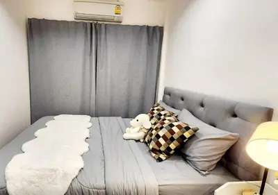 a white teddy bear sitting on a bed with pillows at Cozy House,4 rooms, bts ,Mega Bangna,Suvarnabhumi in Bangkok
