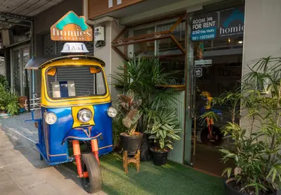 a blue and yellow motorcycle parked in front of a store at Homies Ratchada Hotel in Bangkok