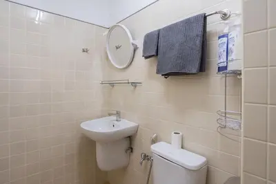a bathroom with a sink and a toilet and a mirror at Homies Ratchada Hotel in Bangkok