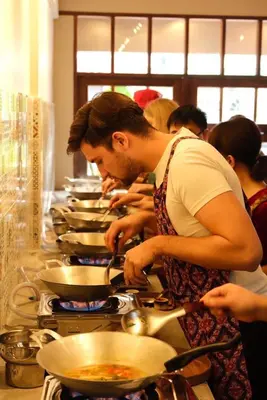 a group of people preparing food in a kitchen at Homies Ratchada Hotel in Bangkok
