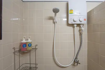 a shower with a shower head in a bathroom at Homies Ratchada Hotel in Bangkok