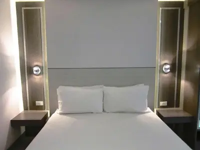a white bed with two nightstands next to a bed sidx sidx at Urban house in Bangkok