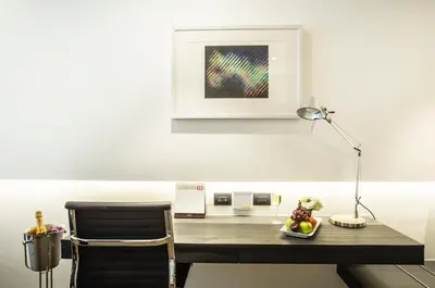 a desk with a lamp and a plate of fruit on it at Amara Bangkok Hotel in Bangkok
