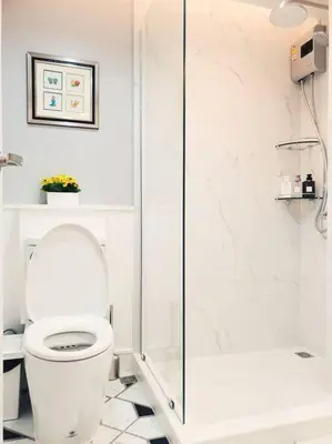 a white bathroom with a toilet and a shower at Double Studio, Private Bath & Balcony, Shared Kitchen with Local Family by Pillows & Purrs in Bangkok