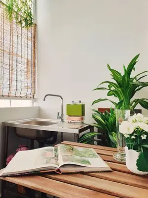an open book on a wooden table with a sink at Double Studio, Private Bath & Balcony, Shared Kitchen with Local Family by Pillows & Purrs in Bangkok