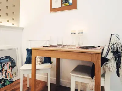 a wooden table with two white chairs and a table at Double Studio, Private Bath & Balcony, Shared Kitchen with Local Family by Pillows & Purrs in Bangkok