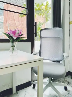 a white office chair next to a desk with a vase of flowers at Single Beds, Private Bath & Balcony, Shared Kitchen with Local Family by Pillows & Purrs in Bangkok