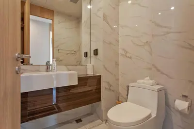 a bathroom with a sink and a toilet and a mirror at New 2-Bedroom Apartment in Asok in Bangkok