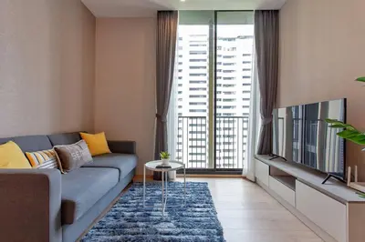 a living room with a blue couch and a television at New 2-Bedroom Apartment in Asok in Bangkok