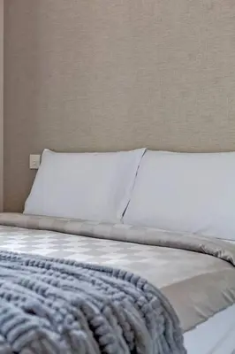 a bed with a white pillow and a blue blanket at New 2-Bedroom Apartment in Asok in Bangkok
