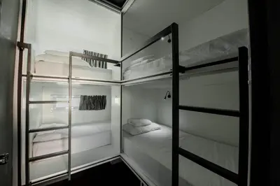 a small room with two bunk beds in it at Mascotte Hostel Silom in Bangkok