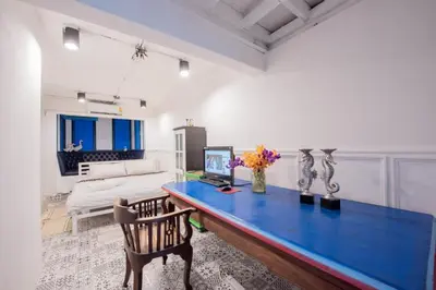 a room with a blue desk with a computer on it at Mascotte Hostel Silom in Bangkok