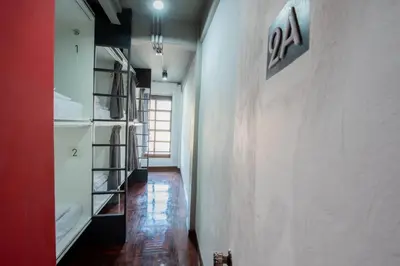 a hallway with a book shelf in a room at Mascotte Hostel Silom in Bangkok